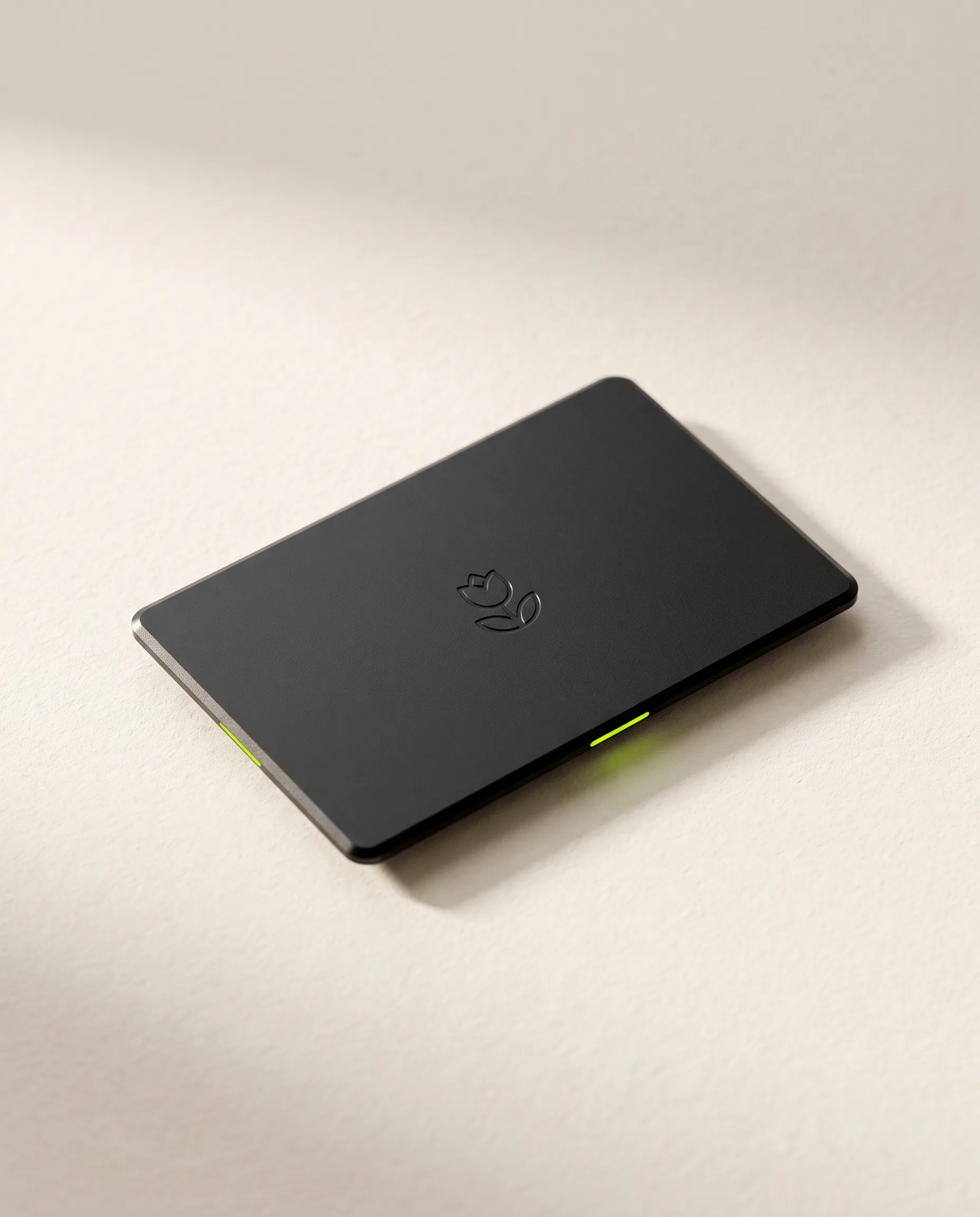 A matte black Bloom Card lying on a warm white surface